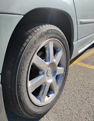 A wheel on a blue car signifying a journey.